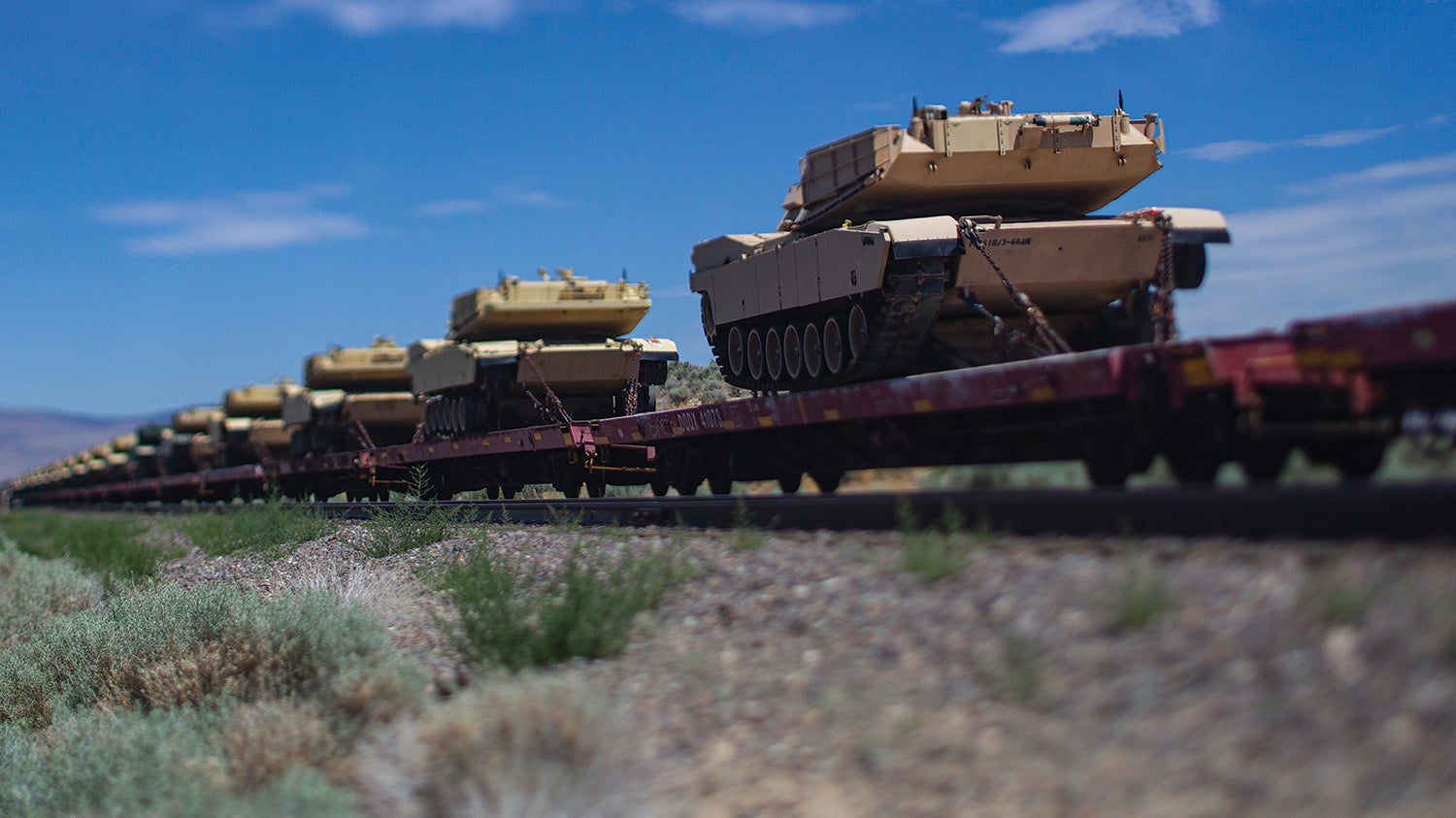 Army M1 Abrams tanks travel atop rail cars at Sierra Army Depot, California. (Credit: U.S. Army/T. T. Parish)