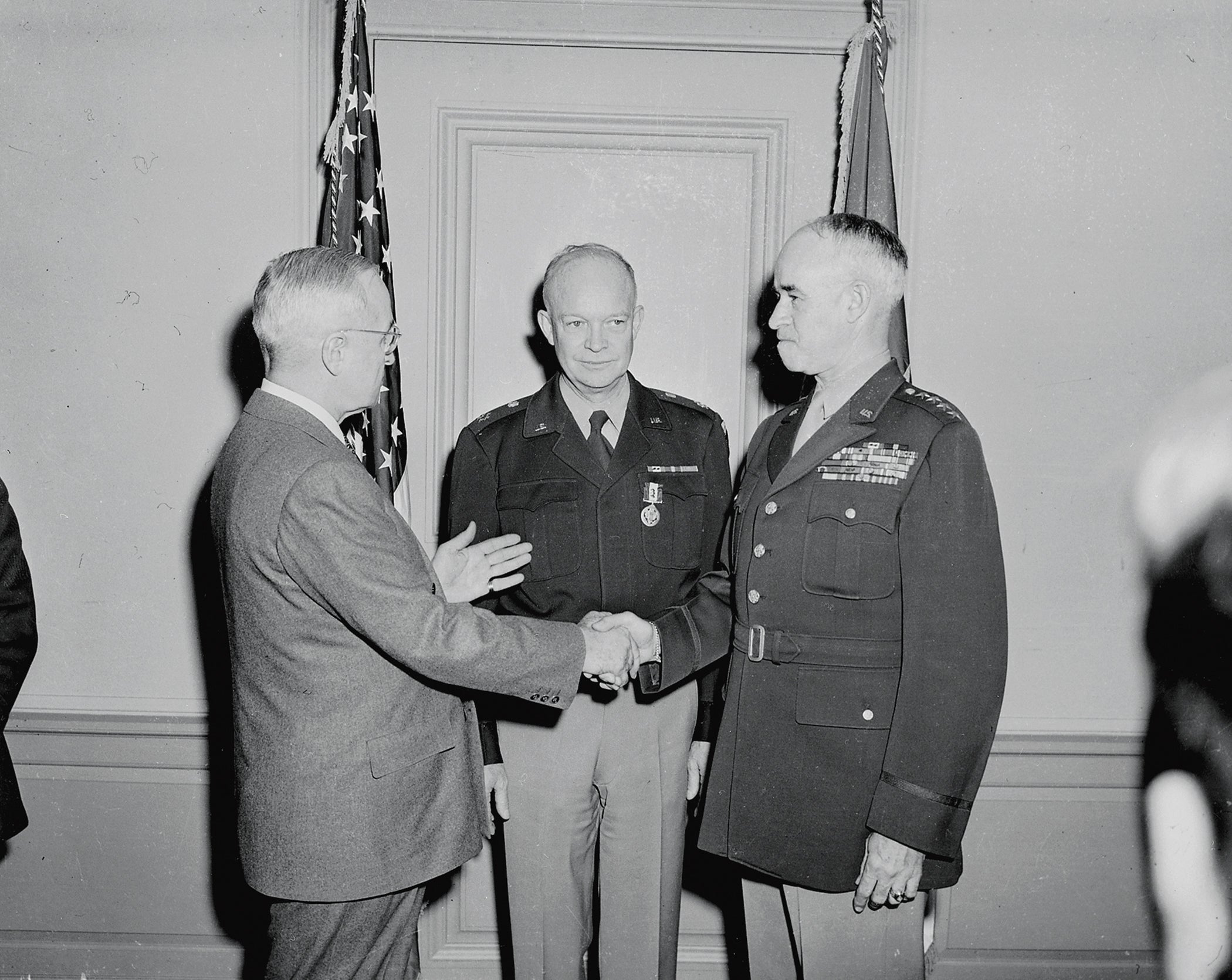 President Harry Truman, left, shakes hands with Gen. Omar Bradley, who has just been sworn in as Army chief of staff, as Gen. Dwight Eisenhower looks on. (Credit: Wikimedia Commons)