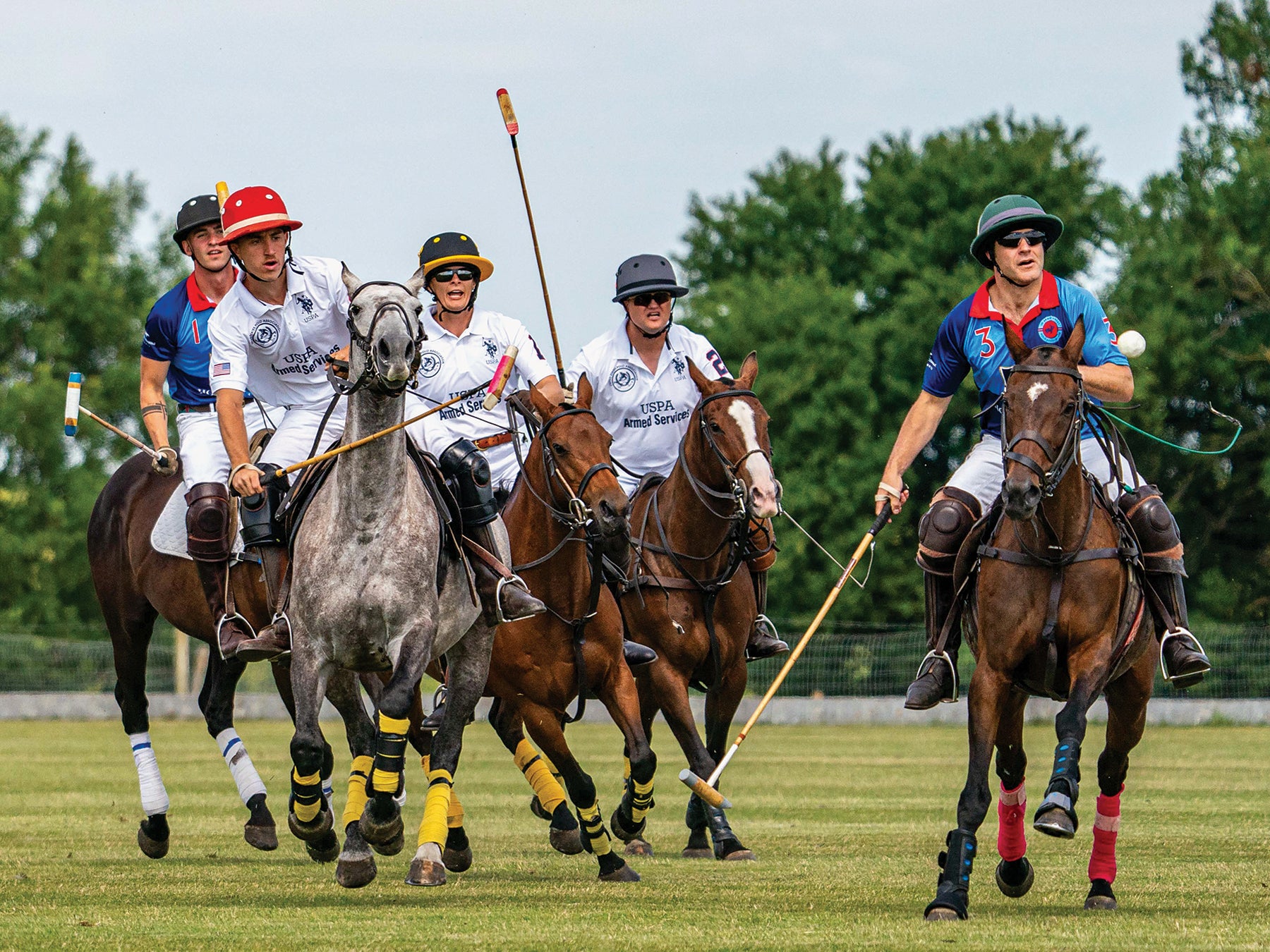 U.S. Army polo players, in white jerseys, take on a British team during a match in England. (Credit: Michael Berkeley Photography)
