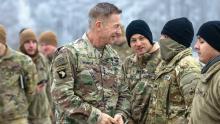 Army Chief of Staff Gen. James McConville, left, presents a challenge coin to a soldier with the 1st Armored Division Combat Aviation Brigade during a visit to Powidz, Poland, in December. (Credit: U.S. Army/Spc. William Thompson)