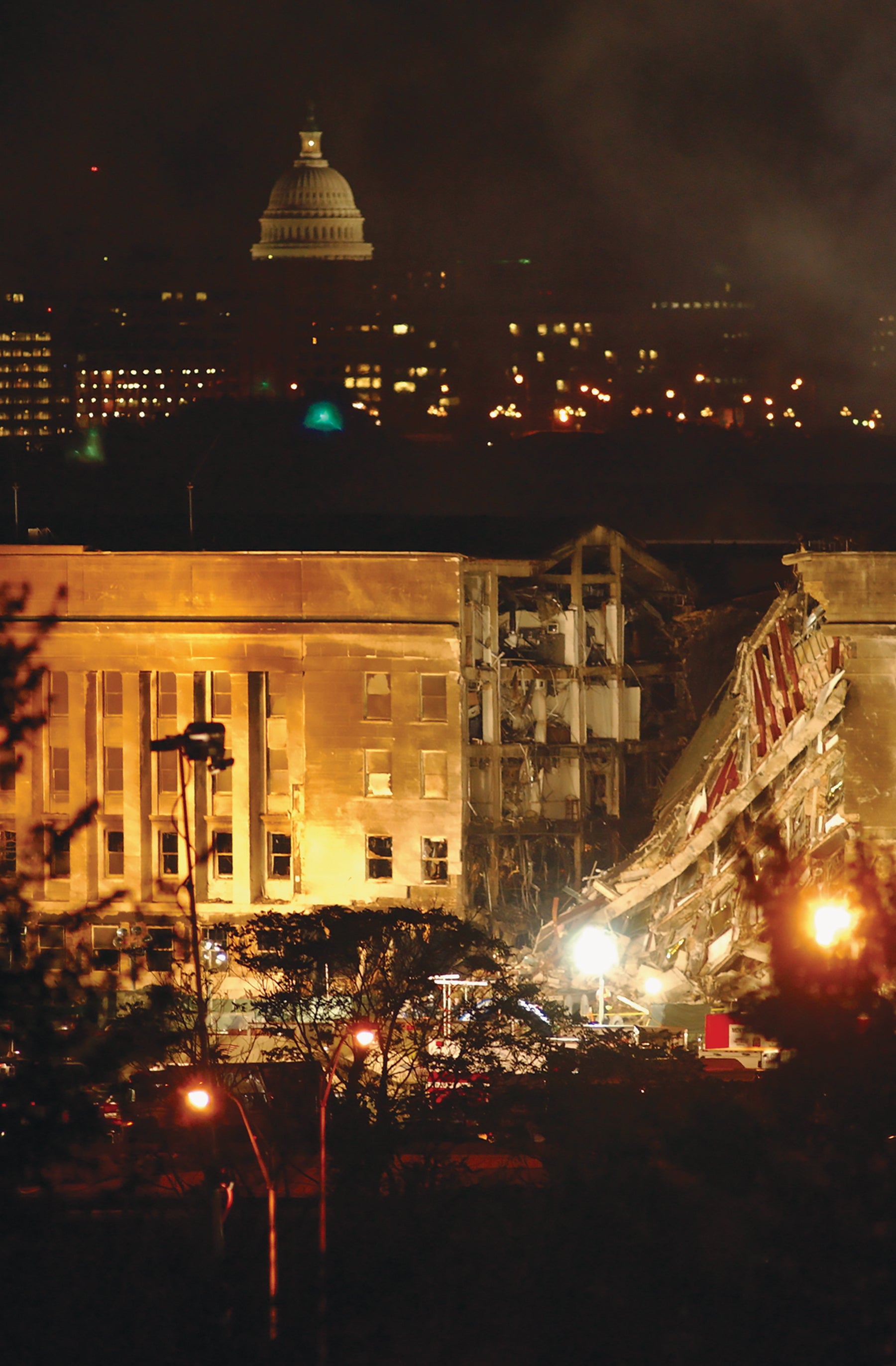 At the Pentagon, firefighters battle smoke and flames and search for survivors late into the night of Sept. 11, 2001, after a hijacked airliner crashed into the building.