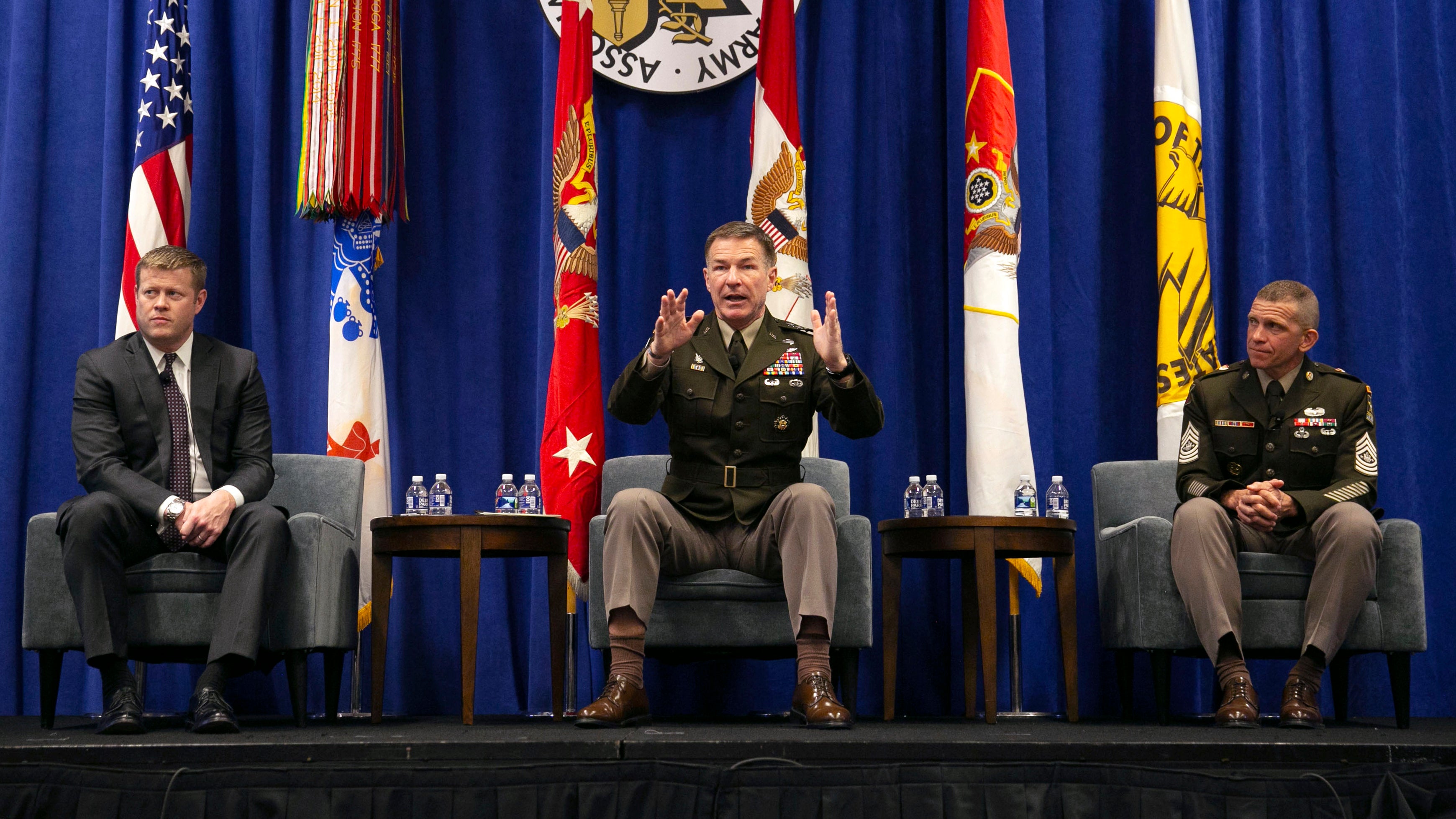 Flanked by Secretary of the Army Ryan Mcarthy, left, and Sergeant Major Michael Grinston, Army Chief of Staff James McConville speaks at the Family Forum IV: Senior Leaders Town Hall at the 2019 AUSA Annual Meeting and Exposition.