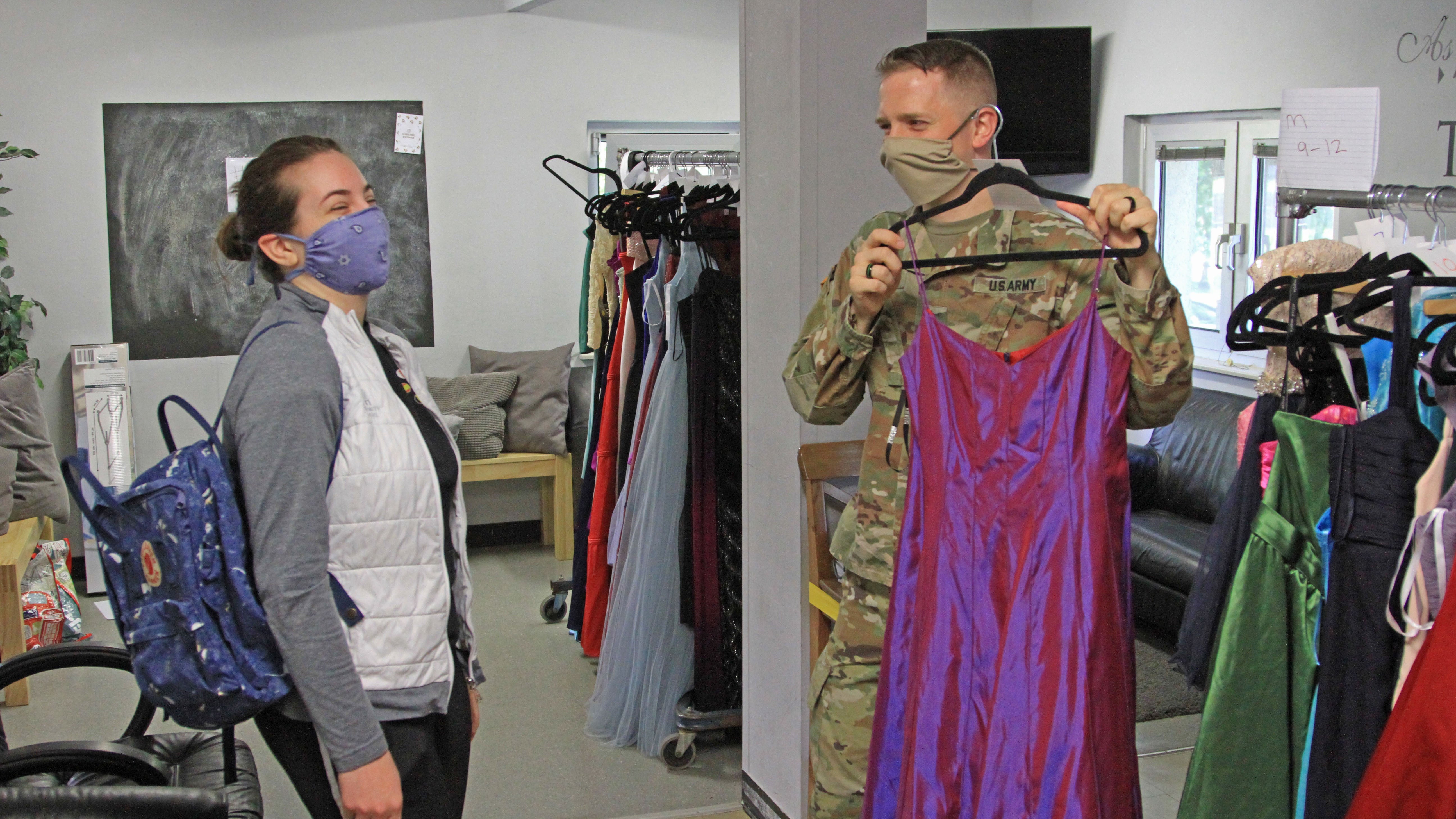 A soldier helps a student during a Deploy Your Dress event.