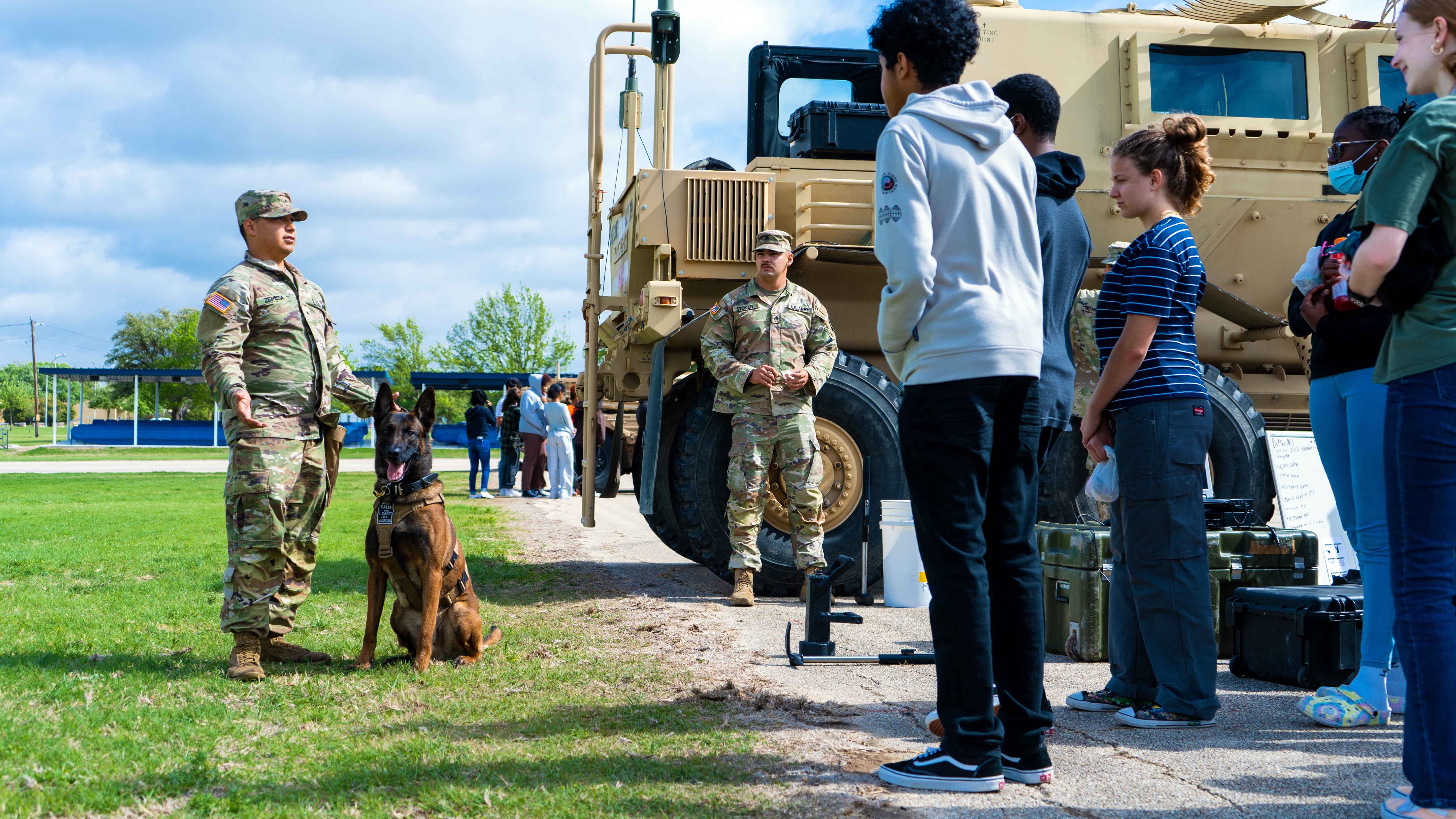 Soldiers with service dog speaking to students
