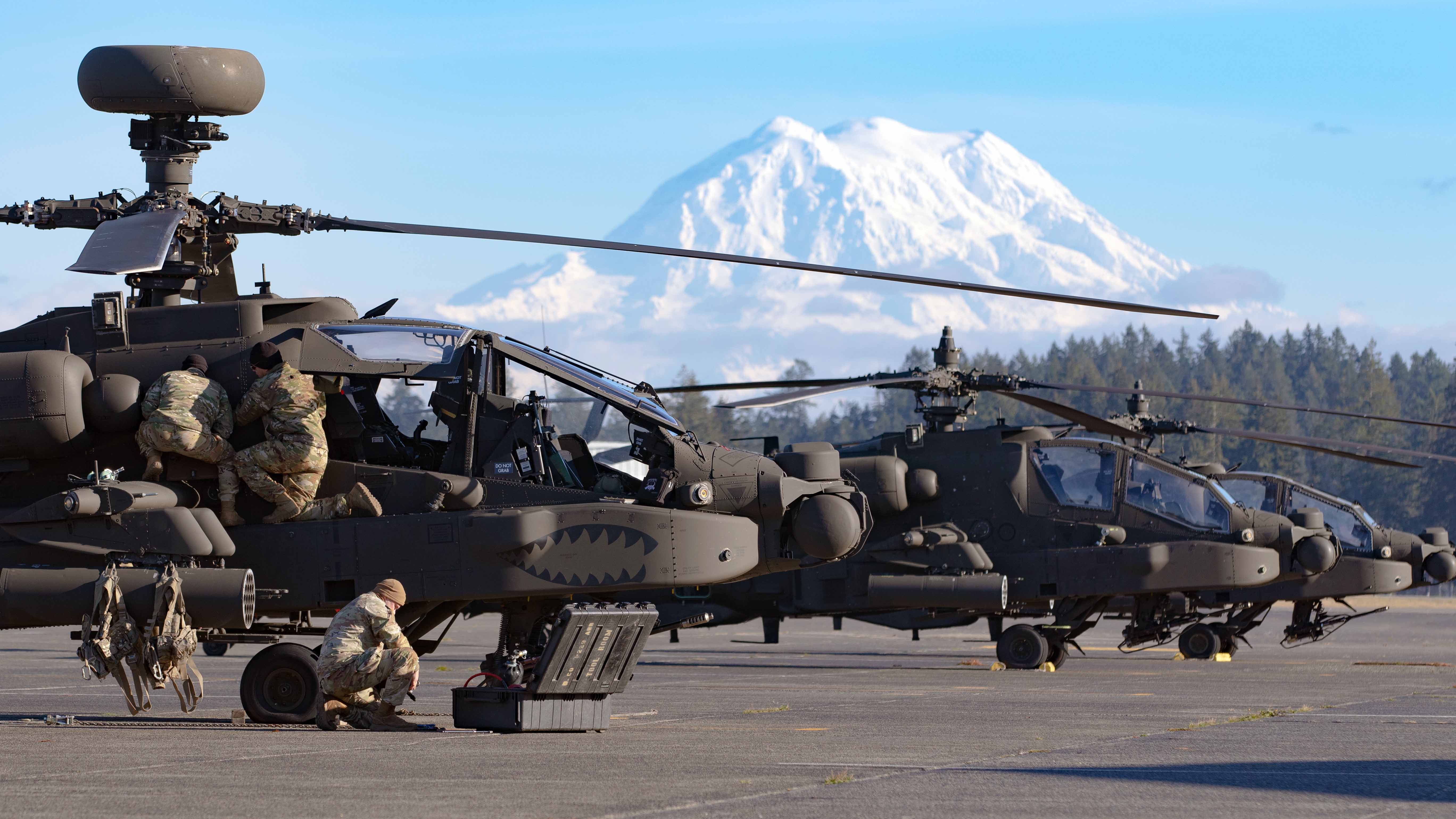 Soldiers assigned to 16th Combat Aviation Brigade perform maintenance on an AH-64E Apache attack helicopter at Joint Base Lewis-McChord, Wash. on Nov. 8, 2022. Mount Rainier is visible in the background. (U.S. Army photo by Capt. Kyle Abraham, 16th Combat Aviation Brigade)