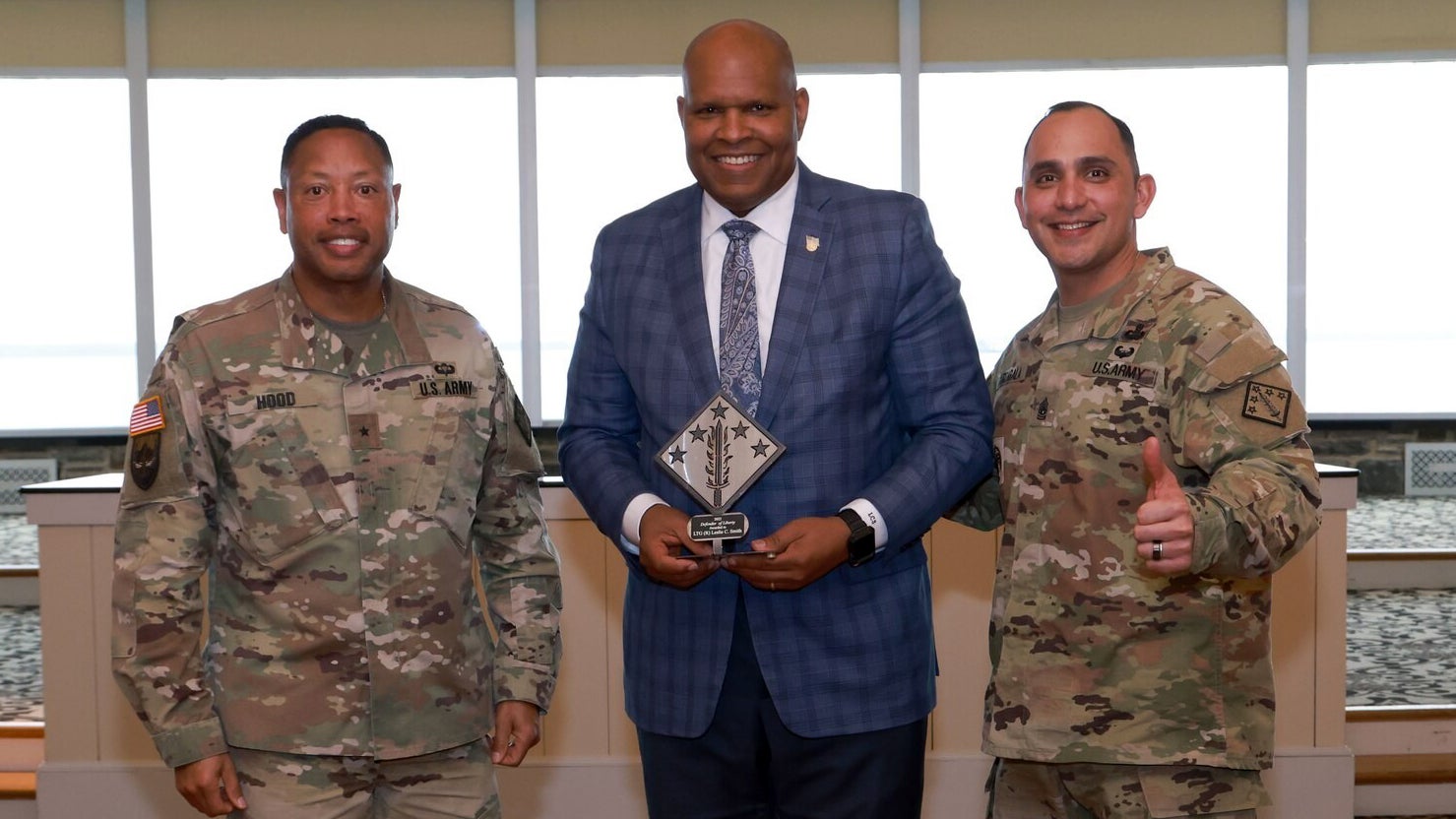 Ret. LTG Les Smith receives an award from two soldiers