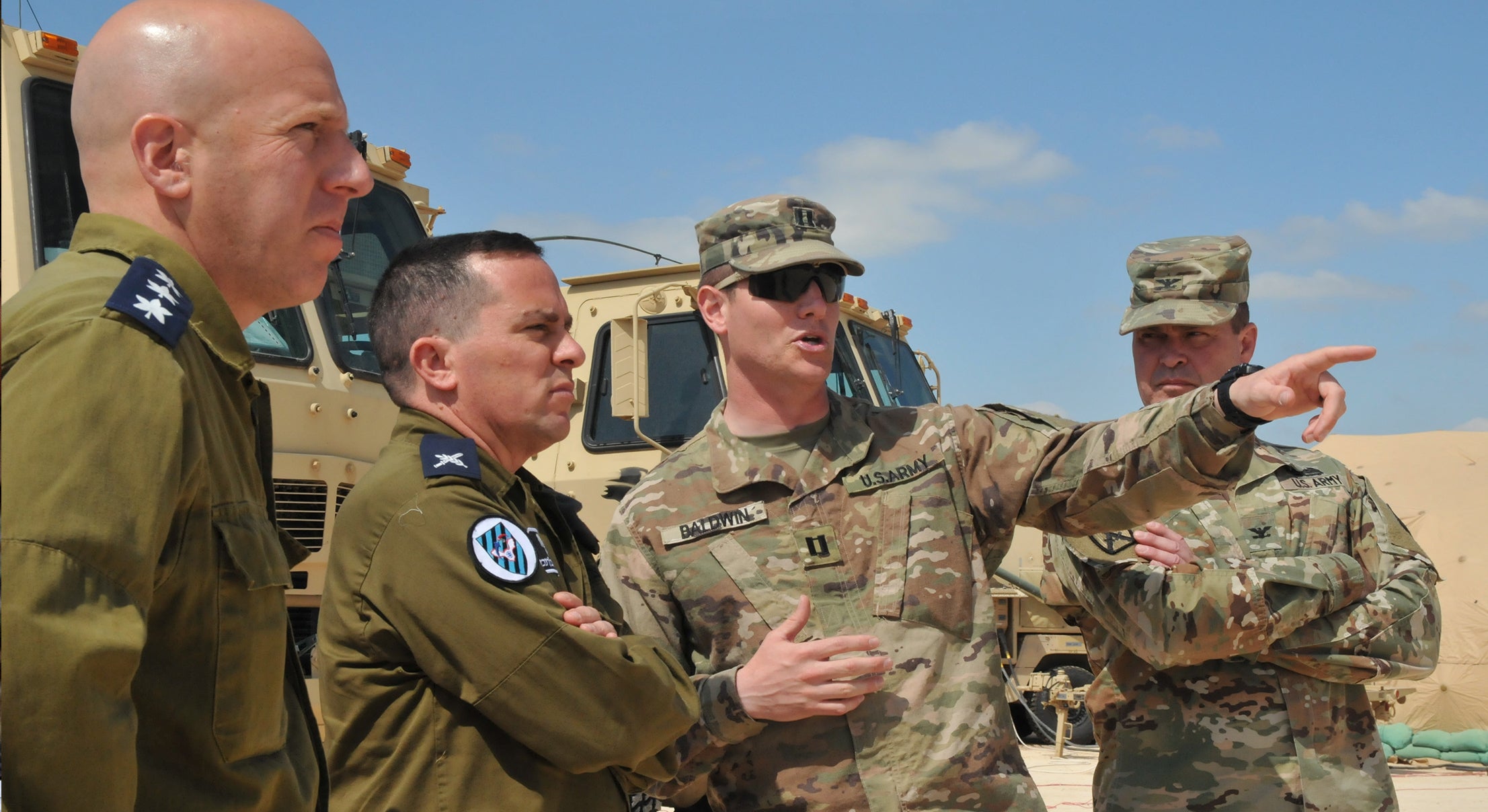 Two IDF Air Force members and two U.S. Army Soldiers standing in front of equipment