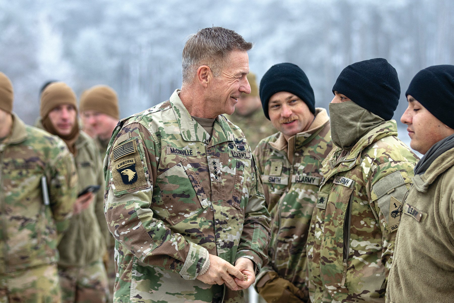 Army Chief of Staff Gen. James McConville, left, presents a challenge coin to a soldier with the 1st Armored Division Combat Aviation Brigade during a visit to Powidz, Poland, in December. (Credit: U.S. Army/Spc. William Thompson)
