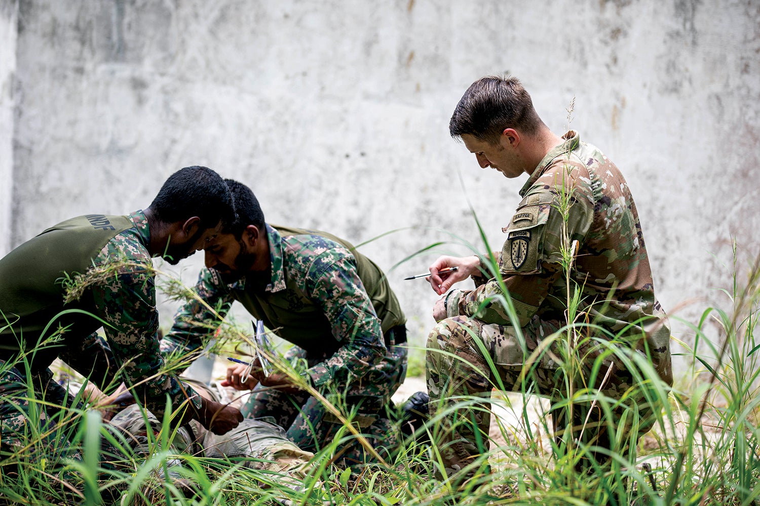 Staff Sgt. Warren Mohan, an adviser with the 5th Security Force Assistance Brigade, observes as members of the Maldives National Defense Force demonstrate tactical field care in Kahdhoo, Maldives. (Credit: U.S. Army/Spc. Jacob Núñez)