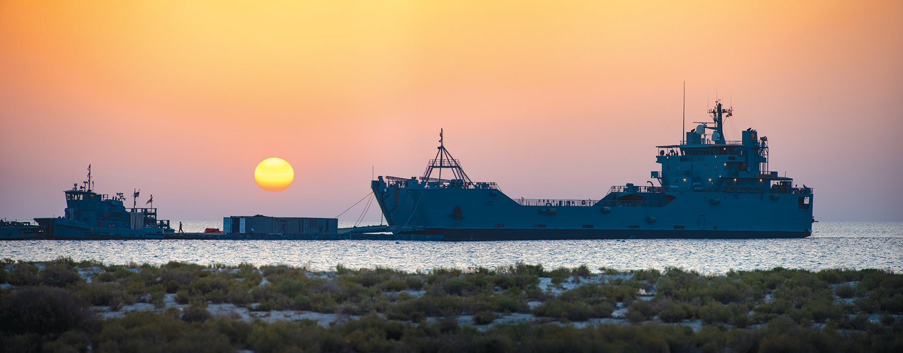 The U.S. Army Vessel Major General Charles P. Gross, a Logistics Support Vessel, and a smaller tugboat are moored during a joint logistics-over-the-shore exercise in the United Arab Emirates. (Credit: U.S. Army/Spc. Travis Teate)