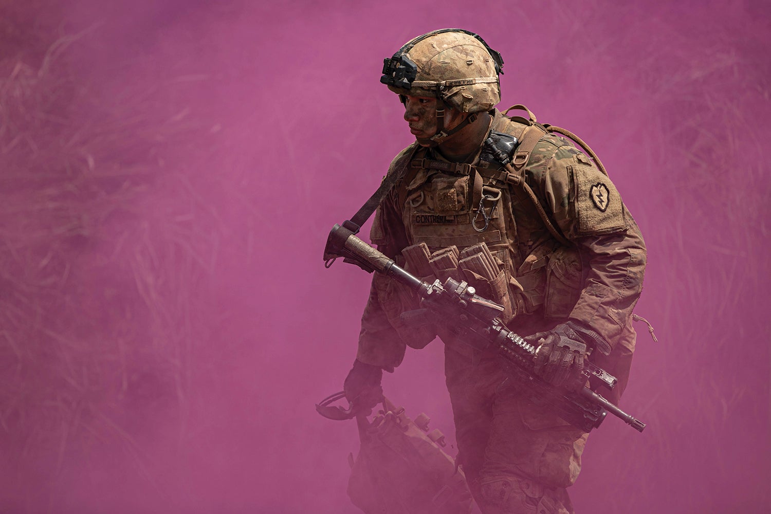 A soldier walks through violet smoke after live-fire training at Baturaja Training Area, Indonesia. (Credit: U.S. Army/ Spc. Rachel Christensen)
