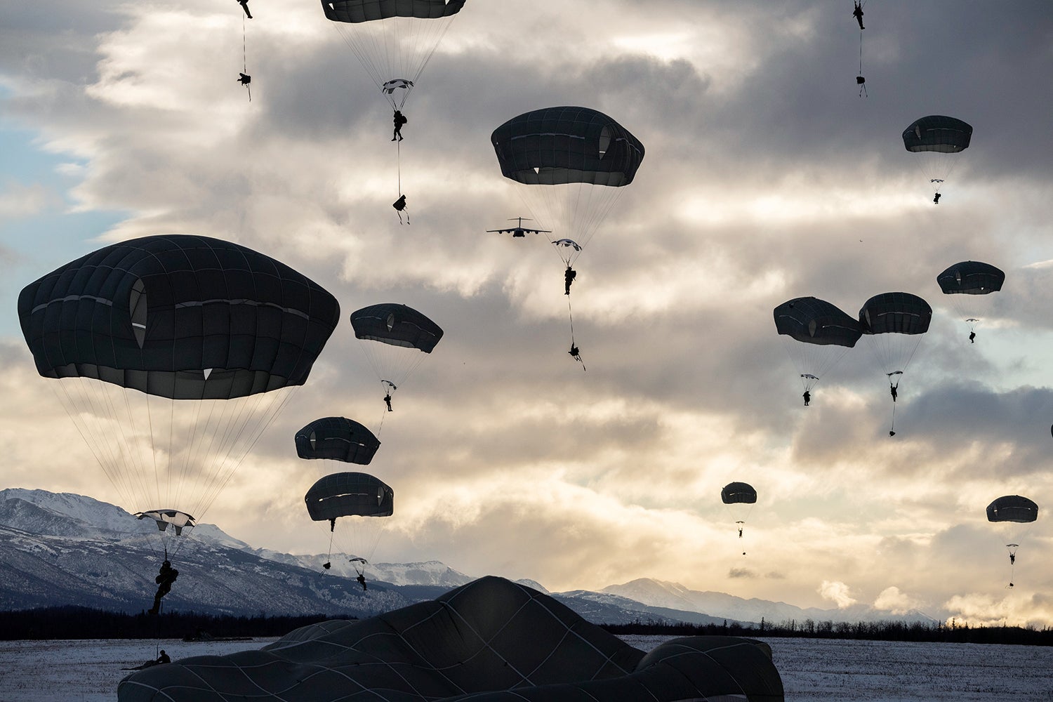 Soldiers with the 2nd Infantry Brigade Combat Team (Airborne), 11th Airborne Division, descend over Malemute Drop Zone, Joint Base Elmendorf-Richardson, Alaska. (Credit: U.S. Air Force/Alejandro Peña)