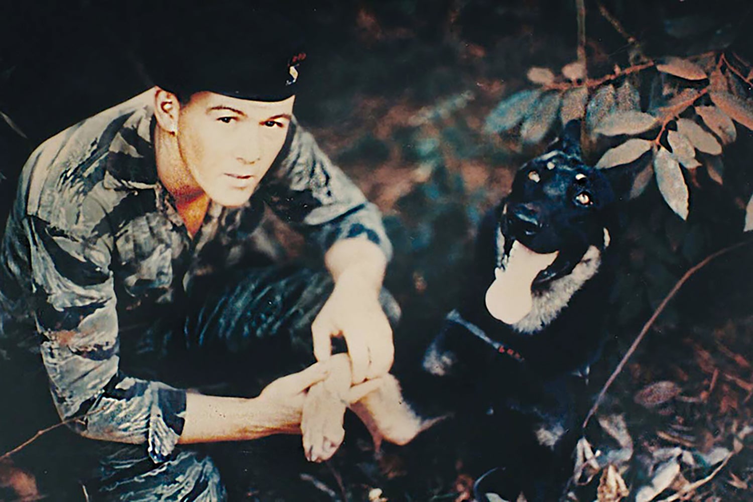 Sgt. David Hill, one of four members of a long-range reconnaissance team rescued by Taylor on June 18, 1968, is pictured with a military working dog in Vietnam. (Credit: Courtesy of Thomas McMahon)