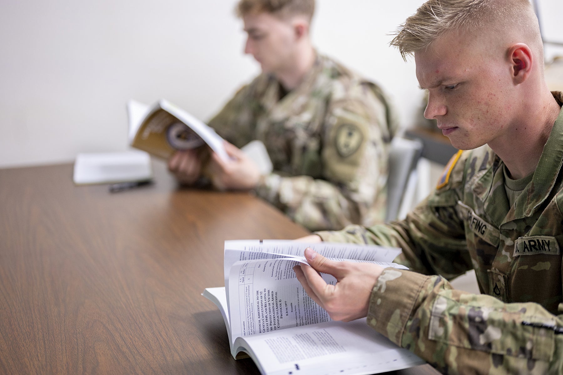 Pfc. Bryce Grafing, right, a paralegal specialist with the U.S. Army Reserve’s 300th Military Police Brigade, 200th Military Police Command, reads instructional material during a class at Fort McCoy, Wisconsin. (Credit: U.S. Army/Staff Sgt. Ryan Rayno)