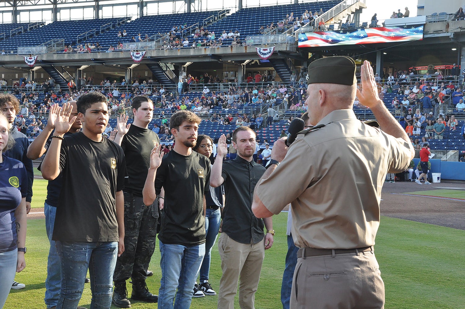 Maj. Gen. John Kline, commander of the U.S. Army Center for Initial Military Training, swears in 25 Army recruits at a Norfolk Tides Armed Forces Night baseball game in Norfolk, Virginia. (Credit: U.S. Army)