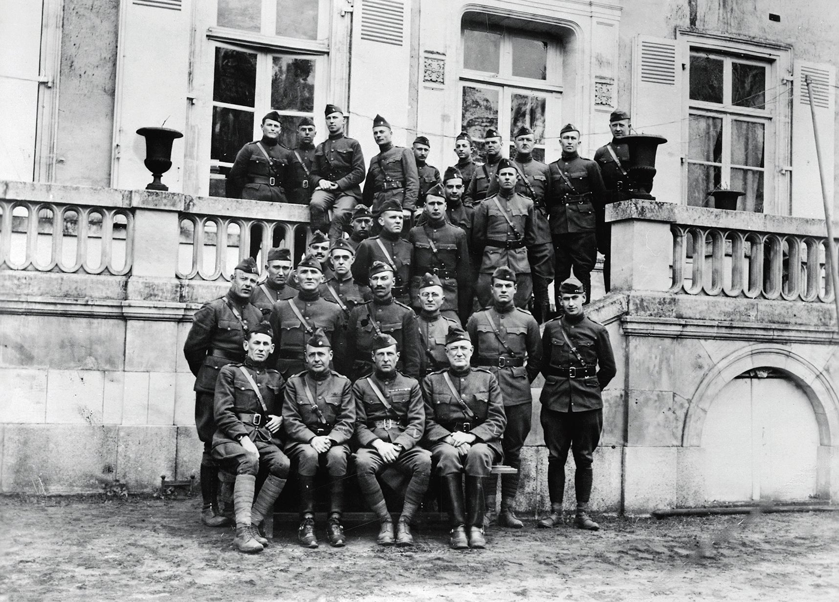 Truman, third from right in the second row, with other officers of the 129th at regimental headquarters near Courcemont, France, in March 1919. (Credit: Wikipedia)