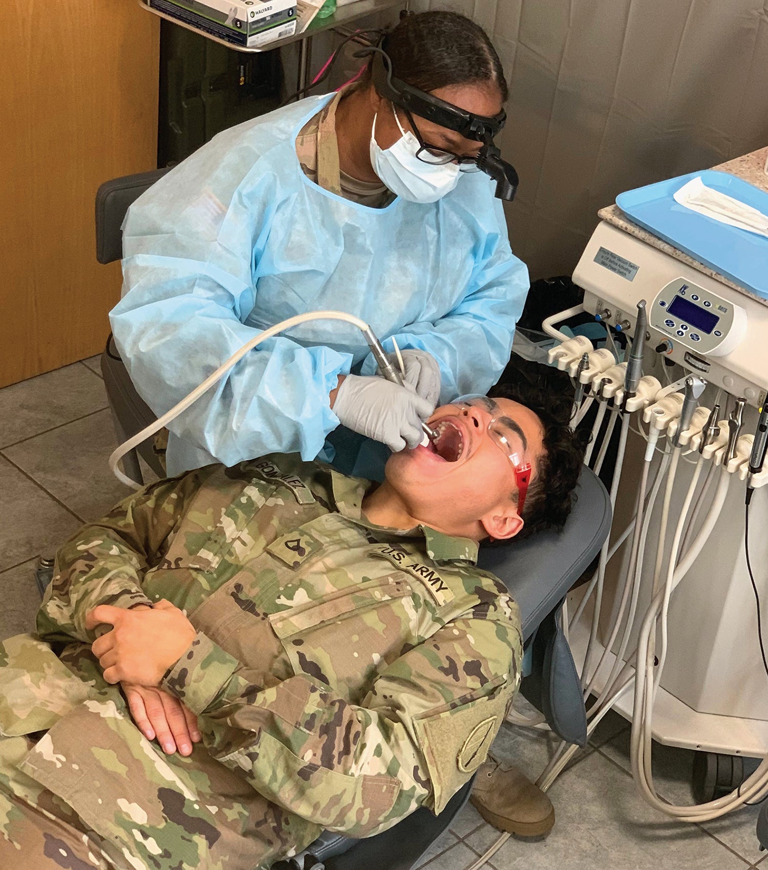 Maj. Mitisha Martin performs a dental exam on Pfc. Alonso Gonzales while deployed to Poland in 2020. (Credit: Army National Guard/Spc. Paige Sipe)