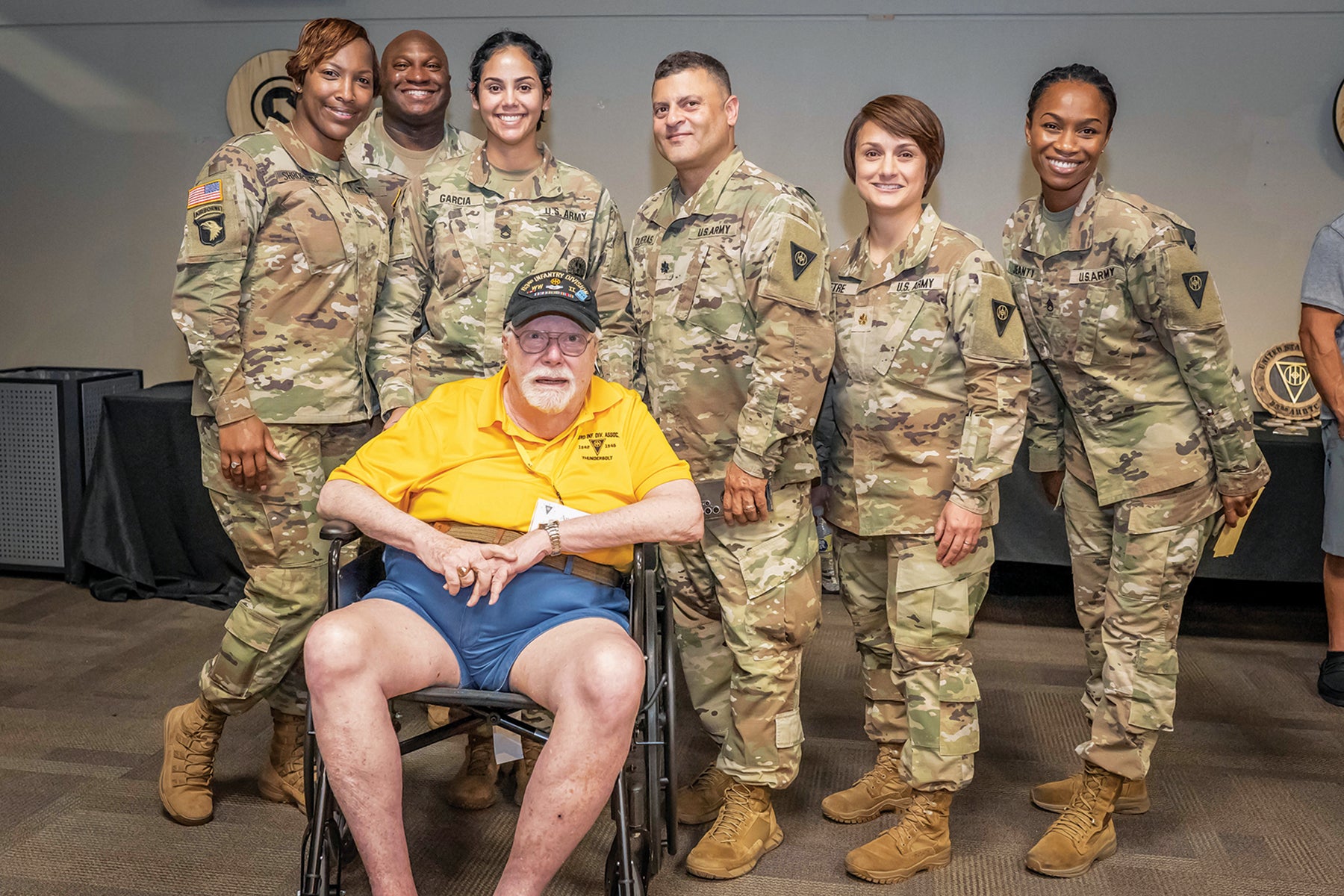 Soldiers pose for a photo with former Pvt. Andre Beaumont, seated, at the museum. (Credit: U.S. Army/Charles Leffler)