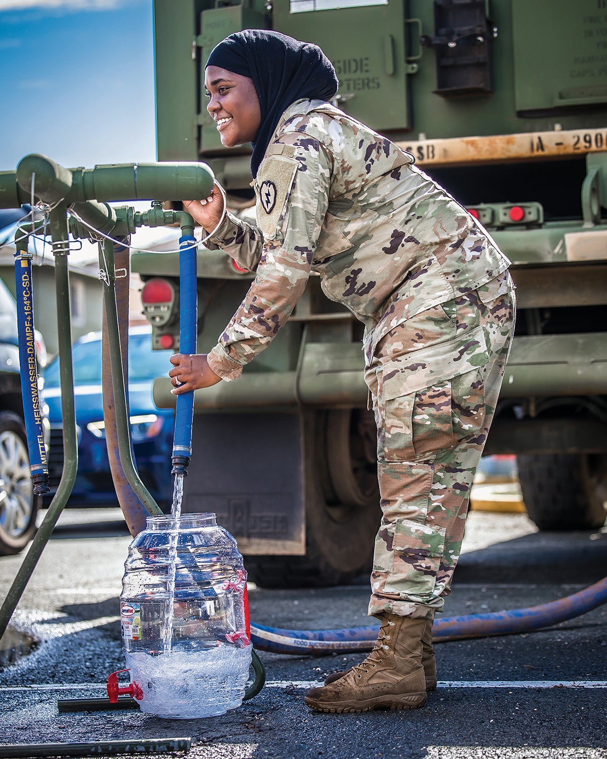 A 25th Infantry Division soldier collects water for distribution to a military neighborhood in Honolulu after officials discovered possible groundwater contamination.