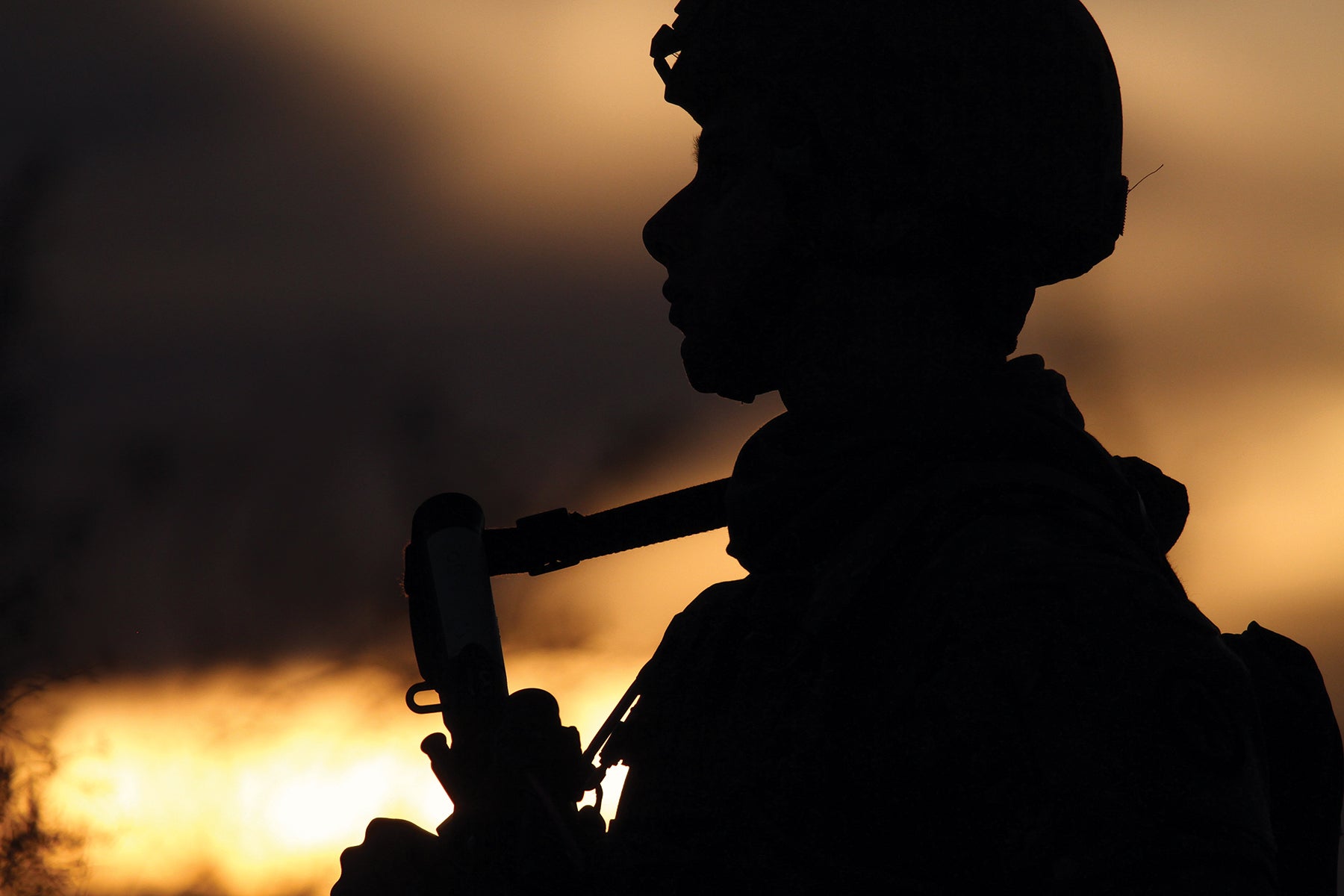 A New Jersey Army National Guard soldier appears in silhouette as the sun sets.