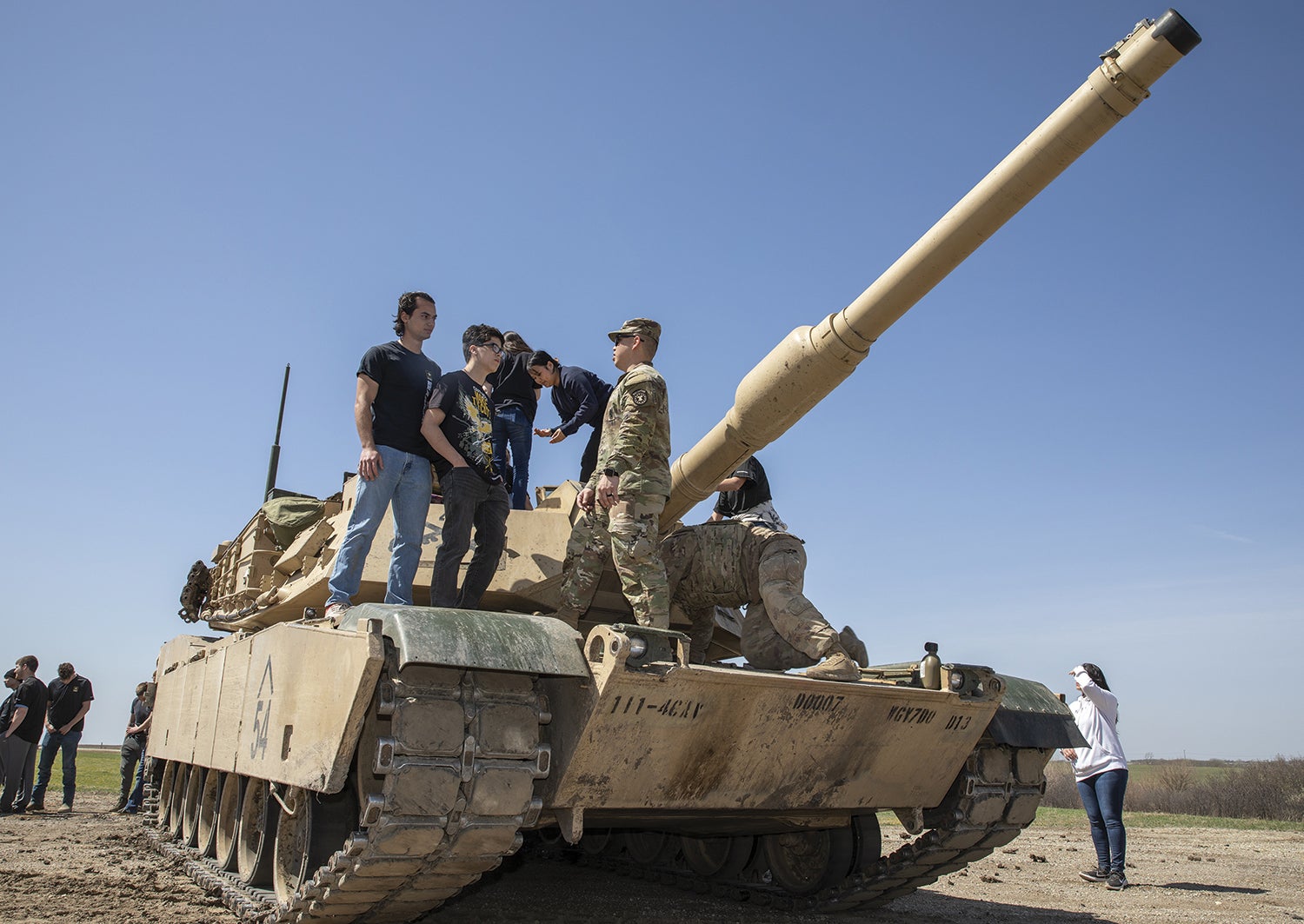Staff Sgt. Jason Nguyen, right, a recruiter with the Kansas City Recruiting Battalion, talks to prospective soldiers about life in the Army while standing on an M1A1 Abrams tank at Fort Riley, Kansas. (U.S. Army/Sgt. Jared Simmons)