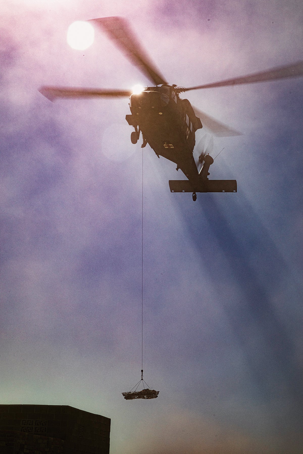 A UH-60 Black Hawk helicopter demonstrates a litter hoist system during Project Convergence 2021 at Yuma Proving Ground, Arizona. (Credit: U.S. Army Scott Childress)