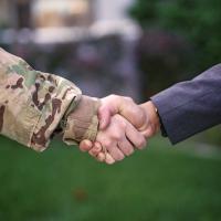 Soldier shaking hands with businessman.