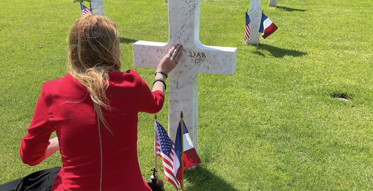 Anna Gdak visits the grave of her great-uncle, Frank Gdak, at the Aisne-Marne American Cemetery, France. Frank Gdak was killed during World War I. (Credit: Heather Warfield)