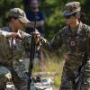 Capt. Danielle Rant, left, gets an assist from Sgt. Christine Won as she adjusts a rifle sling during a competition at Camp Ethan Allen Training Site, Vermont.